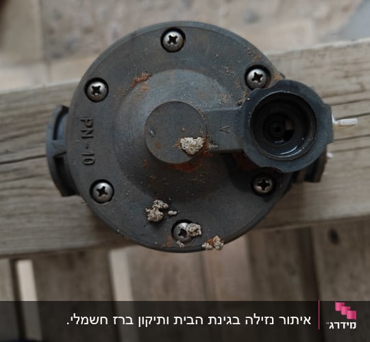 שסתום מתכת עם חלודה על עץ